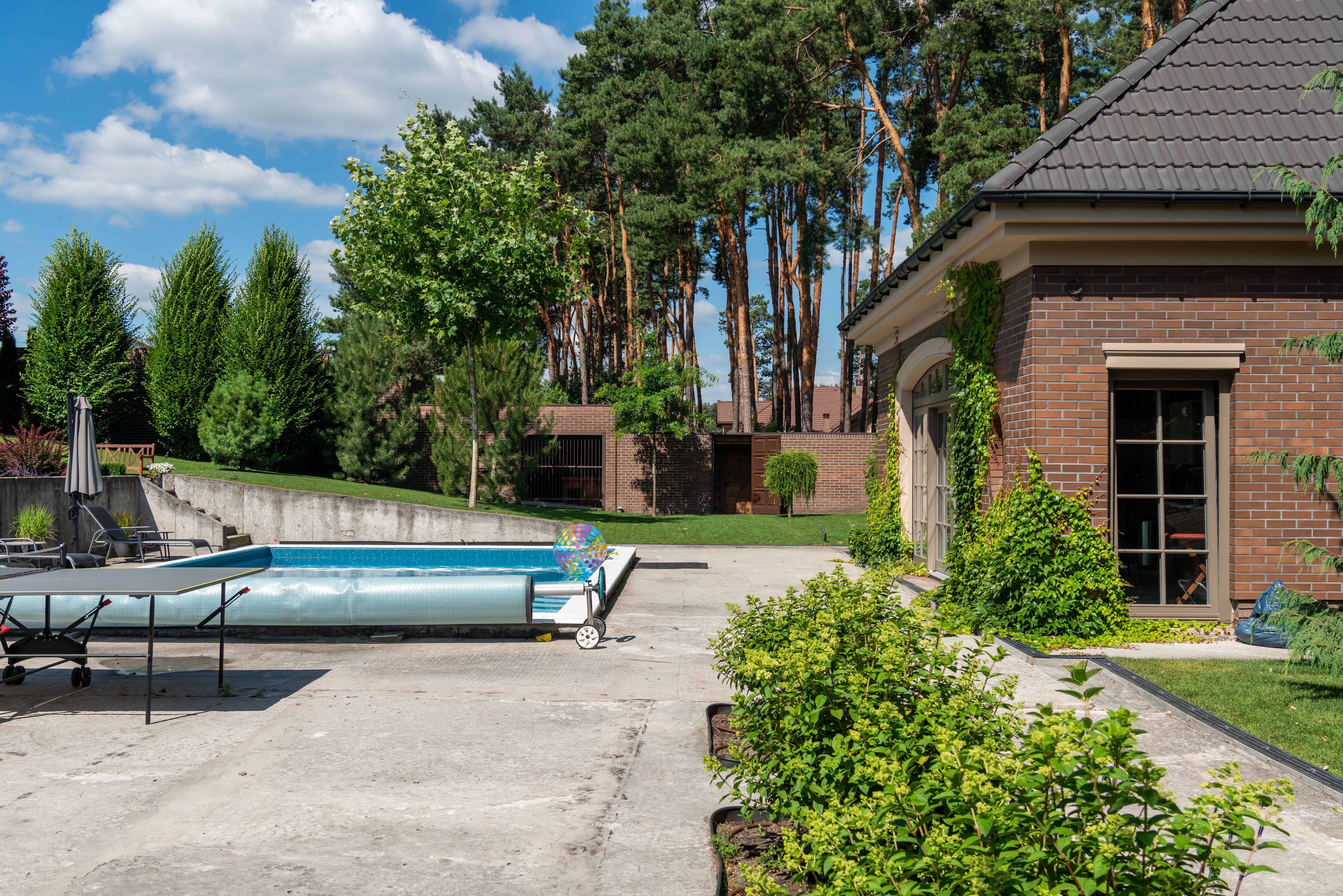 Suburban home with a private swimming pool and lush backyard greenery