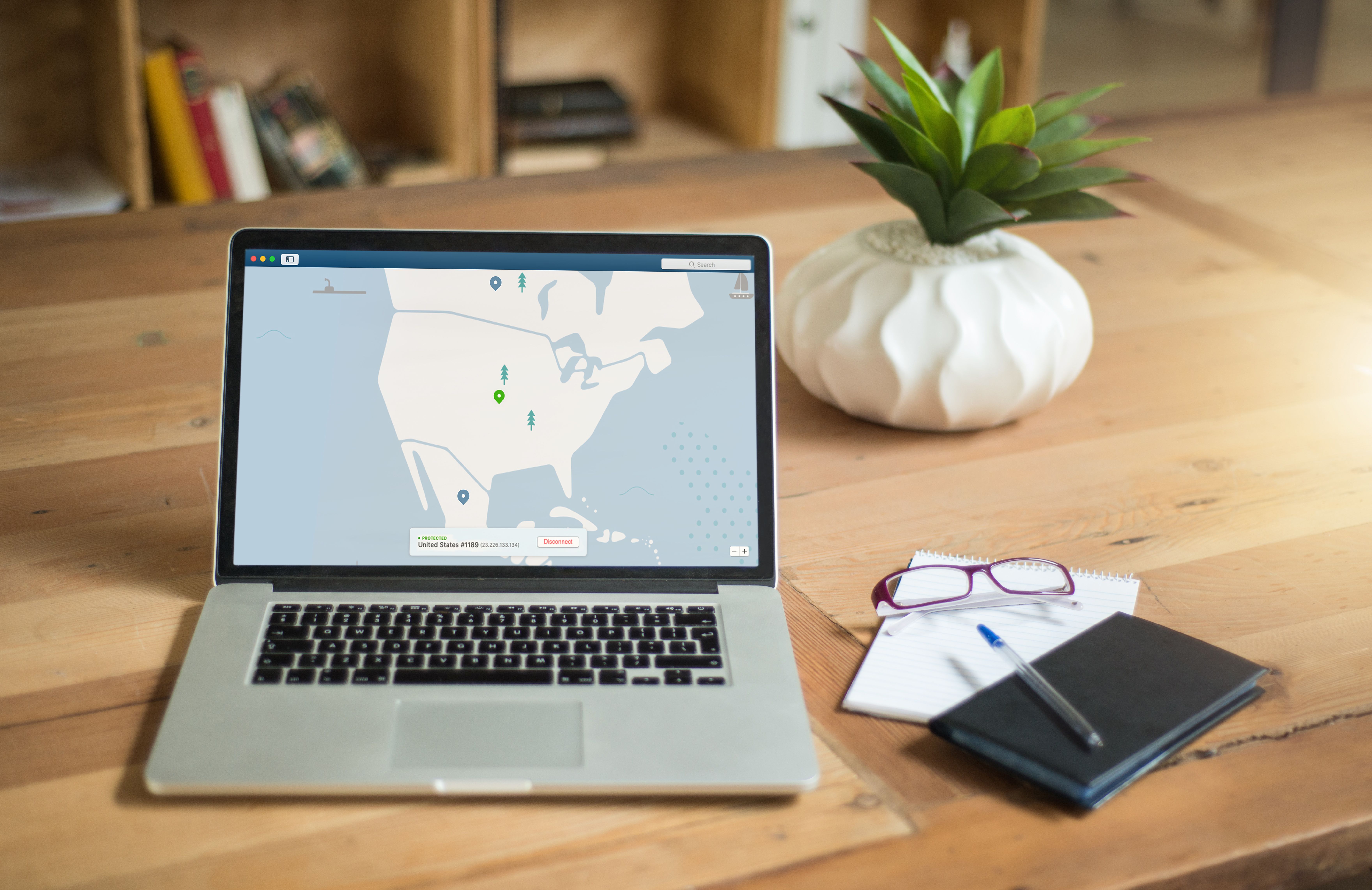 Laptop displaying VPN software on a desk, representing digital privacy and secure client information.