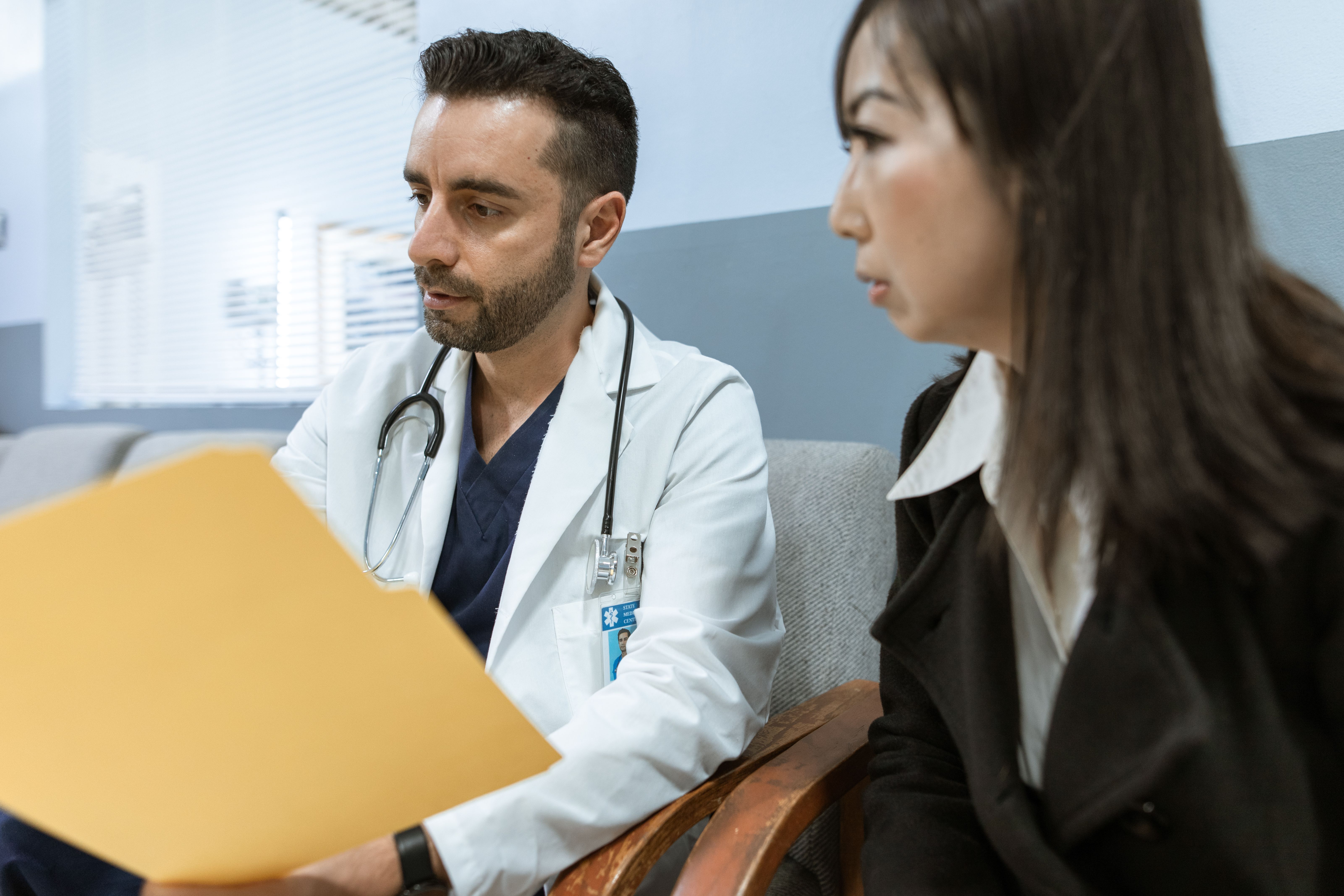 Doctor reviews health records with a patient during a private medical consultation.